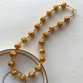 Necklace with gold topaz appliqué over gold Murano glass sphere beads on gold